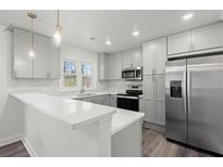 Modern kitchen featuring white cabinets, stainless steel appliances, quartz counters, and stylish pendant lighting at 1892 Buford Dam Rd, Buford, GA 30518