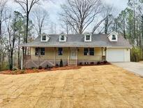 Newly constructed yellow house with front porch and attached garage, landscaping in progress at 46 Mcmichen Rd, Dallas, GA 30157
