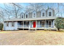 Ranch style home with gray roof, blue siding, and a large front porch at 3898 Buckland Dr, Lilburn, GA 30047
