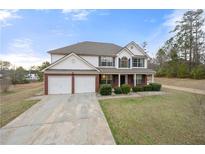Charming two-story home with a well-manicured lawn, covered porch, and two-car garage at 12103 North Hill Ct, Hampton, GA 30228