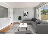 Cozy living room with a large window and gray sectional sofa is perfect for relaxation at 3453 Eisenhower E Cir, Atlanta, GA 30354