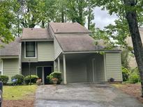Charming home with a covered carport, lush landscaping and mature trees in a desirable neighborhood at 104 Woodhaven Way, Alpharetta, GA 30009