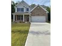 Charming two-story home features a brick facade, attached two-car garage, and concrete driveway at 2180 Highridge Point Dr, Lithia Springs, GA 30122