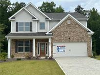 Charming brick and gray two-story home with covered front porch at 2180 Highridge Point Dr, Lithia Springs, GA 30122