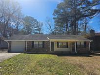 Charming single-story home with a brick facade, attached garage, and a well-maintained front lawn at 432 Independence Dr, Jonesboro, GA 30238