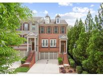 Beautiful three-story townhome with a brick facade, two-car garage, and manicured landscaping at 3261 Ferncliff Ln, Atlanta, GA 30324