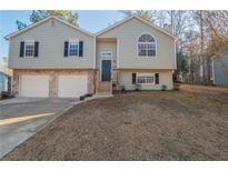 Two-story house with gray siding, stone accents, and a two-car garage at 6305 Holborne Ln, Douglasville, GA 30134