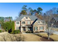Charming brick home featuring a well-manicured lawn, complemented by mature trees and professional landscaping at 123 Fernwood Dr, Woodstock, GA 30188