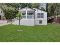 Charming craftsman style home with a white exterior, teal door, and a well-manicured lawn at 235 Holly Nw Rd, Atlanta, GA 30314