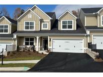 Tan two-story home with white garage door and landscaping at 2503 Wollerton St # 2503, Cumming, GA 30040