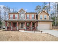Two-story house with stone accents, red shutters, and a porch at 1005 Greenridge Trl, Loganville, GA 30052
