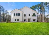 Stunning modern farmhouse exterior boasts a spacious lawn and pristine landscaping at 130 Wesley Pl, Fayetteville, GA 30214