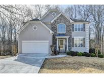 Charming two-story home with stone accents, attached two-car garage and professionally landscaped yard at 355 Holland Springs Way, Powder Springs, GA 30127