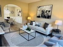 Stylish living room featuring neutral tones, modern furniture, and an open layout to the dining area at 355 Holland Springs Way, Powder Springs, GA 30127