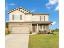 Charming two-story home featuring brick accents, neutral siding and a well-manicured lawn at 8819 Sibella Ct, Lithia Springs, GA 30122