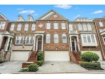 Charming brick townhome featuring a two-car garage and well-maintained landscaping at 5104 Leeshire Se Trl # 64, Atlanta, GA 30339