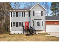 Charming two-story home with gray siding, black shutters, red front door, and attached two car garage at 4390 Allgood Pl, Stone Mountain, GA 30083