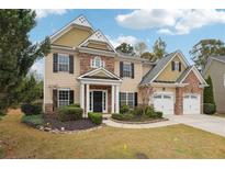 Two story house with stone and shingle accents, two car garage, and landscaped yard at 2005 Creek Pointe Way, Villa Rica, GA 30180