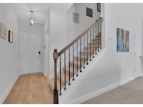 Modern staircase with metal railing and light wood flooring at 11988 Lovejoy Crossing Pl, Hampton, GA 30228