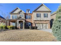 Two-story home with brick and stone accents, a two-car garage, and a well-maintained front lawn in a suburban setting at 4610 Point Rock Dr, Buford, GA 30519