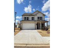 Two-story home with brick and siding, a white garage door, and a landscaped yard at 317 Lavender Ln, Holly Springs, GA 30115