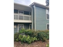 View of the exterior of a two-story condo building with lush landscaping and a balcony at 2824 Vinings Central Se Dr # 146, Atlanta, GA 30339