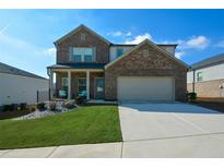 Two-story brick home with a large driveway and landscaped lawn at 309 Bowfin Trl, Mcdonough, GA 30253