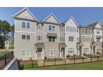 Three-story townhouses with gray siding, brick accents, and black fences at 3304 Cranston Ln, Kennesaw, GA 30144