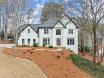 Beautiful two-story white home featuring a well-manicured front yard and detailed black trim at 2025 Cresthaven Walk, Woodstock, GA 30189