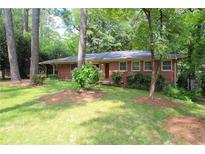 Brick ranch house with a large front yard and mature trees at 1386 Sandy Ln, Decatur, GA 30032