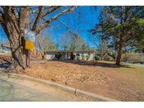 Charming single story home with mature trees and a well-maintained lawn on a sunny day at 16 Bromack Se Dr, Atlanta, GA 30315