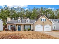 Attractive tan house with two-car garage and landscaping at 5732 Village Loop, Fairburn, GA 30213