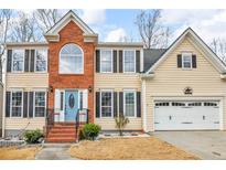 Charming two-story home featuring brick accents, a well-manicured lawn, and a light blue front door at 1175 Evergreen Oak Way, Dacula, GA 30019