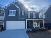 Two-story house with gray siding, white garage door, and landscaping at 817 River Gardens Se Dr, Atlanta, GA 30354