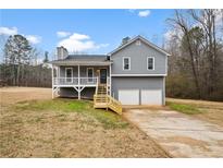 Gray house with white trim, two-car garage, and a deck at 23 Faith Ct, Douglasville, GA 30134
