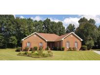 Charming brick home with lush landscaping, manicured lawn, and mature trees at 2509 Fairweather Ct, Conyers, GA 30013