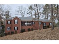 Brick house with a large covered porch and attached two-car garage at 1050 Wiley Bridge Rd, Woodstock, GA 30188