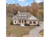 Two story house with stone and shingle exterior, three car garage, and circular driveway at 100 Percheron Dr, Canton, GA 30114