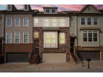 Brick front exterior of a townhome with attached garage and steps leading to the front door at 2134 Old Georgian Nw Ter, Atlanta, GA 30318