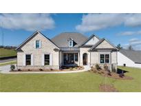 Two-story craftsman style home with light brick exterior, gray roof and landscaping at 233 Laurel Vista Dr, Canton, GA 30115