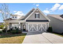 Gray craftsman style home with a three car garage and landscaping at 427 Bluffs View Ln, Canton, GA 30114