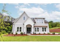 Two story home with gray siding, white accents, and a landscaped lawn at 6565 Rhett Run, Cumming, GA 30028