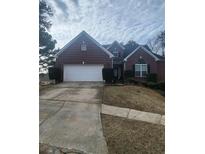 Charming brick home featuring an attached two-car garage and a well-maintained front yard at 633 Herron Ct, Fairburn, GA 30213