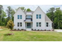 Two-story white brick home with a gray roof and green door at 6585 Rhett Run, Cumming, GA 30028