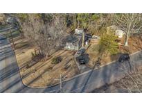 An aerial view of a single-Gathering home, featuring a mature landscaped yard and a long driveway at 6460 Boca Grande Blvd, Forest Park, GA 30297