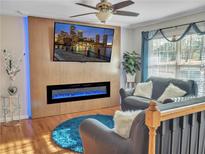 Inviting living room featuring an electric fireplace, ceiling fan, and large screen tv at 6460 Boca Grande Blvd, Forest Park, GA 30297