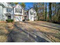 Townhouse exterior with two-car garage and wooded backdrop at 3654 Woodland Cv, Decatur, GA 30034