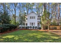 Charming white two-story house with well-manicured lawn and mature trees at 2460 Oldfield Rd, Atlanta, GA 30327