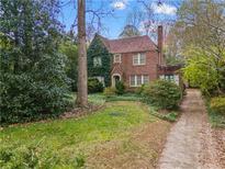 Brick home with a charming facade, lush landscaping, and a private driveway at 1080 Clifton Ne Rd, Atlanta, GA 30307