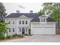 Elegant two-story home with a neutral-toned stucco exterior and a spacious three-car garage and well manicured lawn at 1901 Shelburne Cv, Marietta, GA 30068